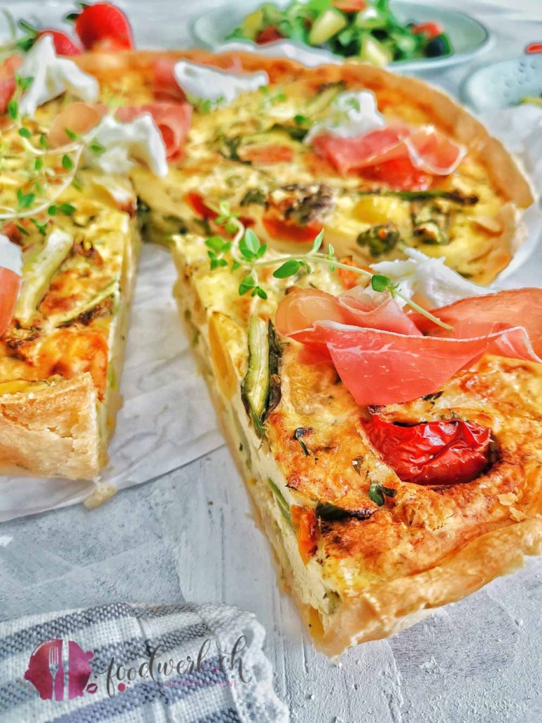 Ein Stück Spargel Wähe mit Rohschinken und Burrata