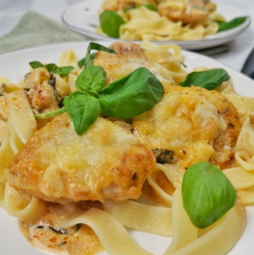 Hähnchen al forno auf Teller mit Nudeln und Basilikum