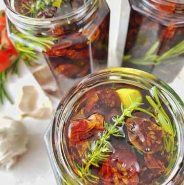 Getrocknete Tomaten und frische Kräuter im Glas