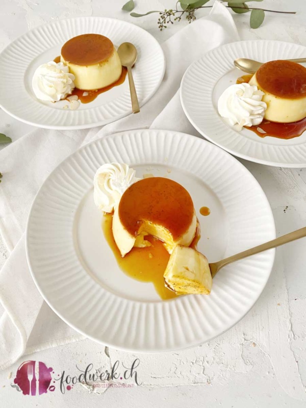 Caramel Köpfchen mit Löffel und geschlagenem Rahm