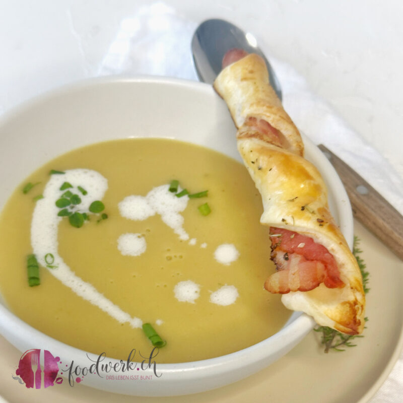 Ein Suppenteller mit cremiger Kartoffelsuppe und knuspriger Speckstange